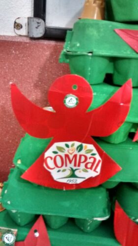 Detalhes de alguns enfeites de Natal onde se vê símbolos da marca Compal, Tetra Pak e FSC e materiais reutilizados com embalagens Tetra Pak, caixas de ovos e cápsulas de café.