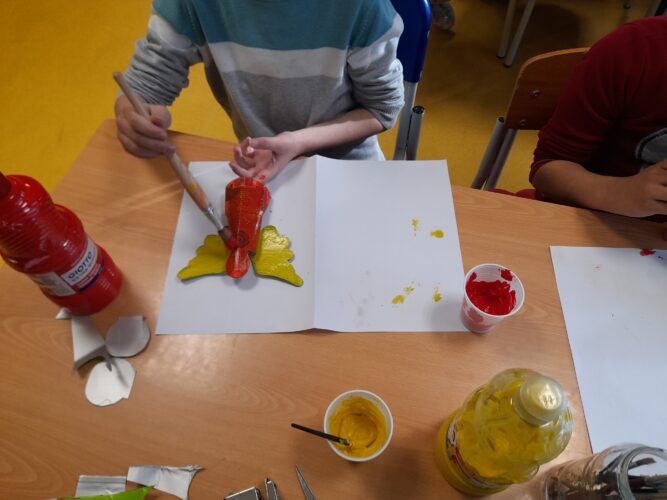 Pintura de alguns enfeites com as cores amarela e vermelho
