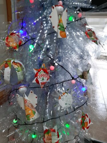 Vários enfeites colocados na árvore que foi elaborada com recurso a garrafas de plástico.
