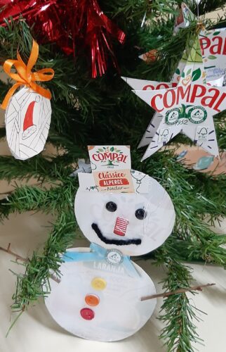 Boneco de neve e estrela de Natal em exposição, sendo visíveis os símbolos FSC® e a marca Compal nas embalagens Tetra PaK usadas.