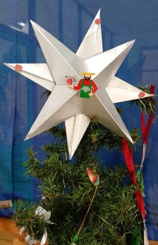 Estrela de Natal em exposição, sendo visíveis os recortes da embalagem e a marca Compal.