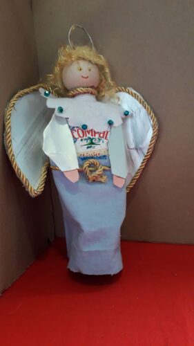 Anjo realizado pela Constança Vivaldo do 6ºE, utilizando uma embalagem Tetra Pack da Compal, tecidos para a roupa do anjo, cordão para decorar as asas, lã para os cabelos e parte de uma cápsula da Nespresso para representar a auréola.