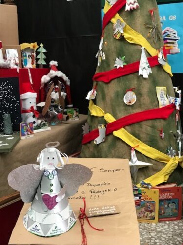 Árvore de Natal decorada com materiais reaproveitados, reutilizados... rodeada dos livros usados que passarão a ter um novo lar neste Natal.