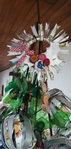 Coroa da árvore de Natal realizada com embalagens tetra-pack compal e flores feitas em tecidos usados.